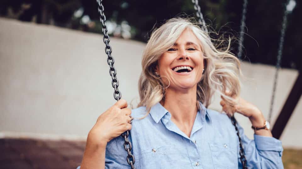 Portrait Of Mature Woman With Gray Hair Sitting On Swing