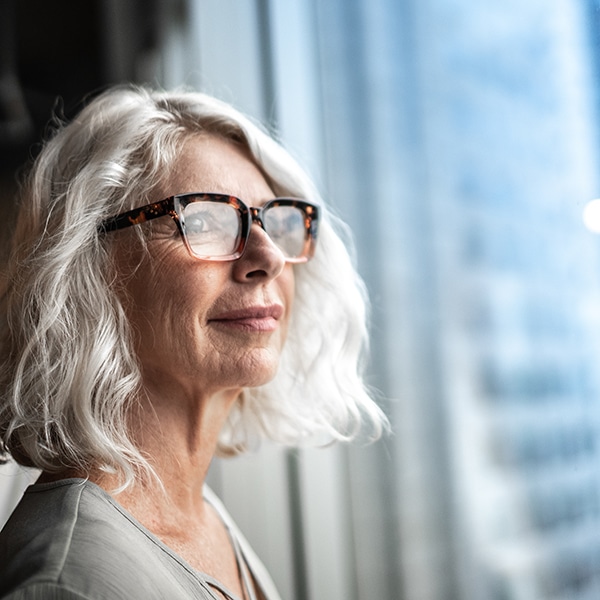 Mature Businesswoman Looking Out Of Window.