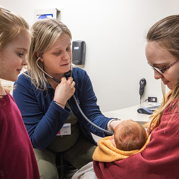 CRMC provider listens to the heartbeat of a new born baby.