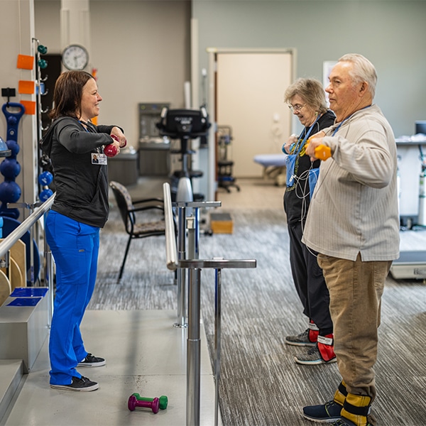 CRMC provider leads elderly patients in rehab exercise.