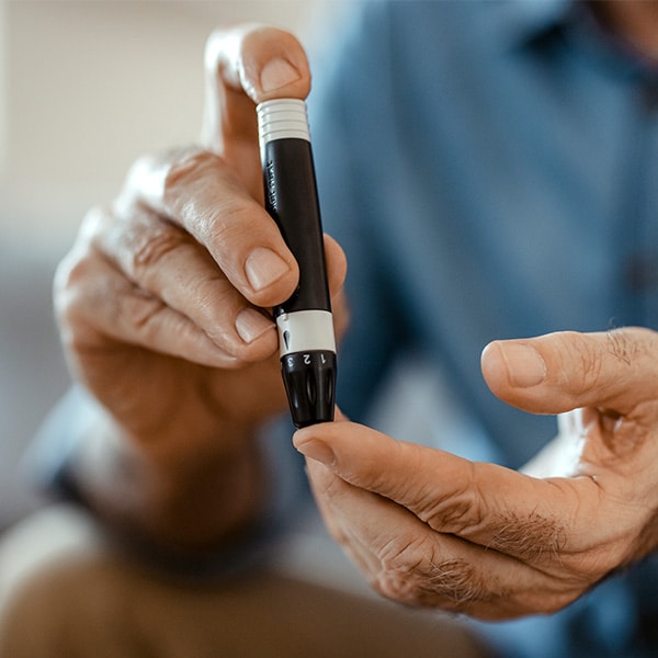 Diabetes patient perfroms finger prick test.