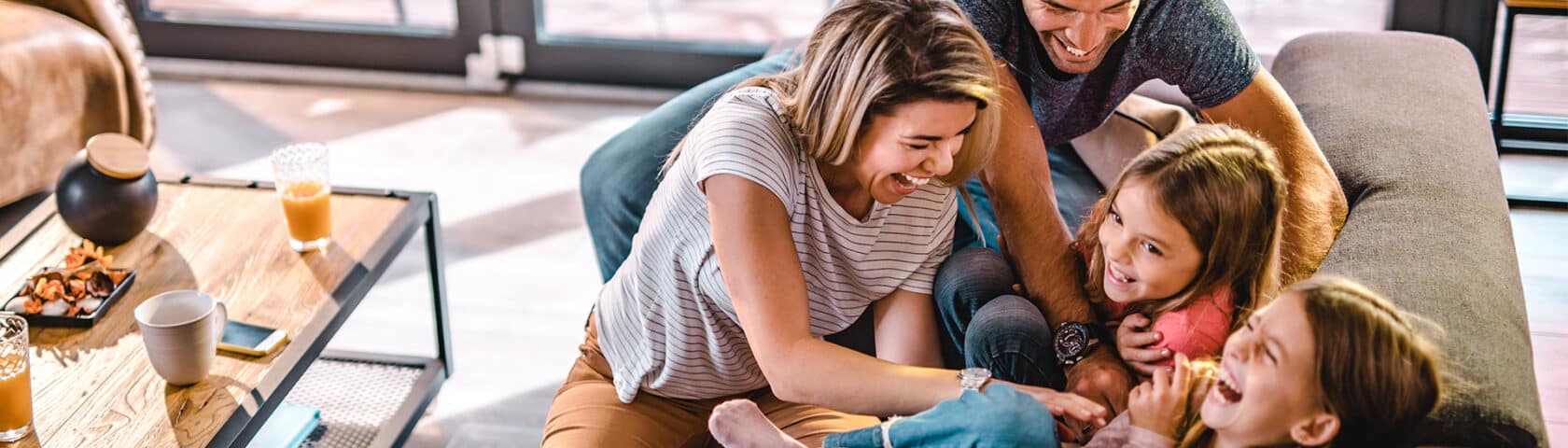Young parents enjoy a fun moment with their two daughters.