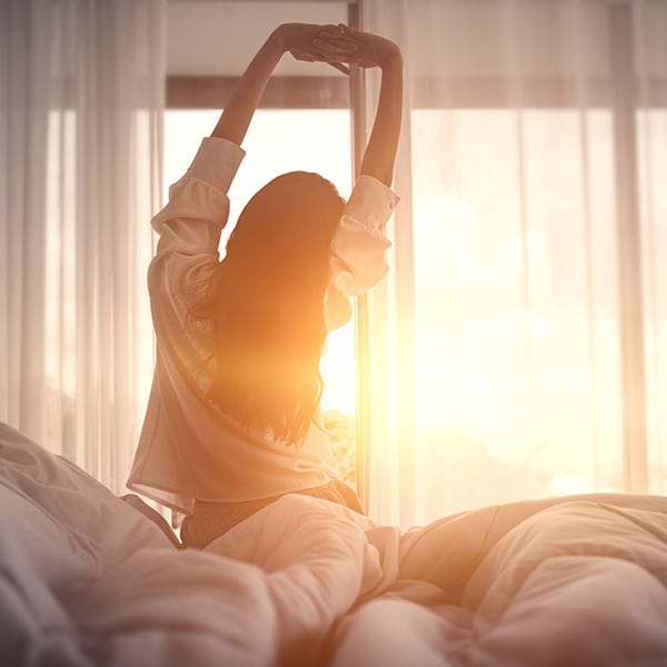 Happy Woman Stretching In Bed After Waking Up. Happy Young Girl Greets Good Day.