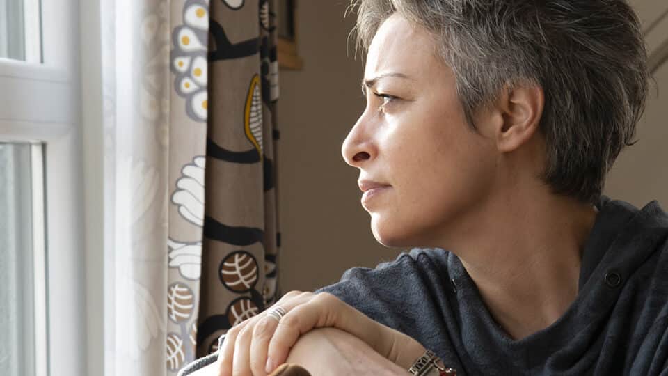 Woman Looking Out The Window At Home