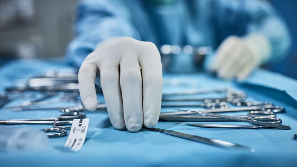Surgeon Picking Up Surgical Tool From Tray