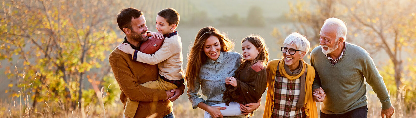 Happy Multi Generation Family Taking A Walk On The Field.