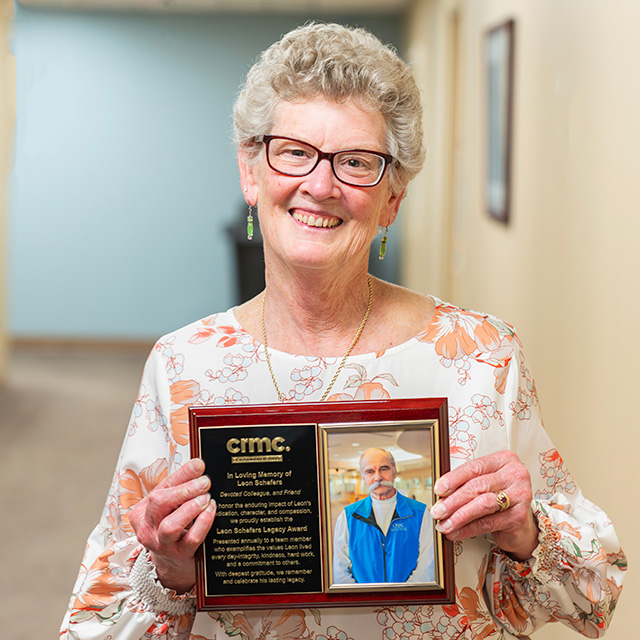 Betsy Liedl accepting a plaque in memory of her husband, Leon Schefer, honoring community spirit.