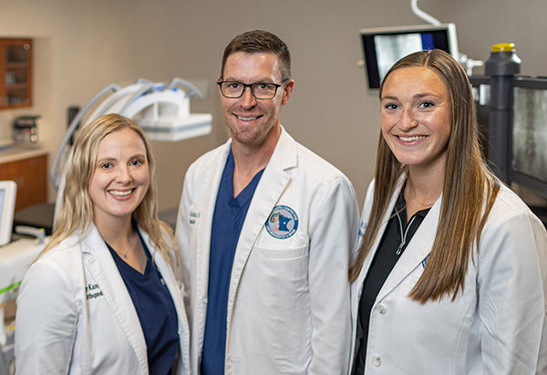 Smiling man hiking outdoors with a backpack, representing spinal health, freedom of movement, and an active, pain-free lifestyle.