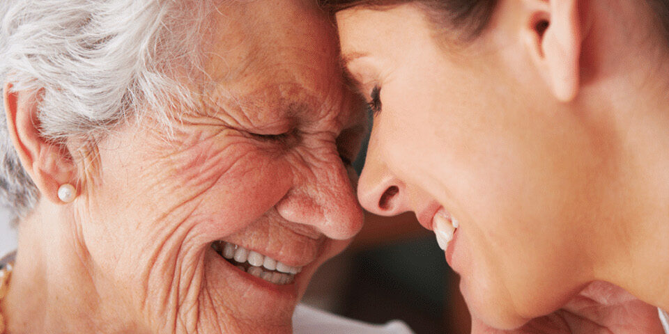 Close-up of an older woman and younger woman smiling together, representing stroke awareness, support, and the importance of recognizing stroke symptoms early.