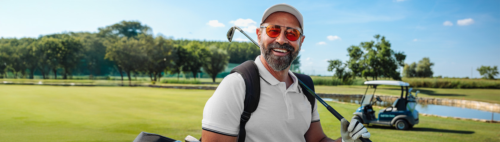 Smiling middle-aged man golfing outdoors, representing the active, everyday life many patients return to with the help of urology care.