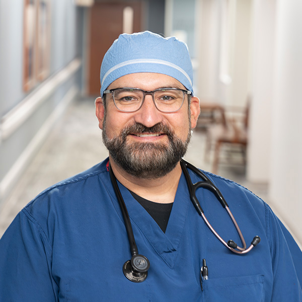 CRNA Andy Frankwick in blue scrubs and surgical cap with stethoscope, anesthesia provider at Cuyuna Regional Medical Center.