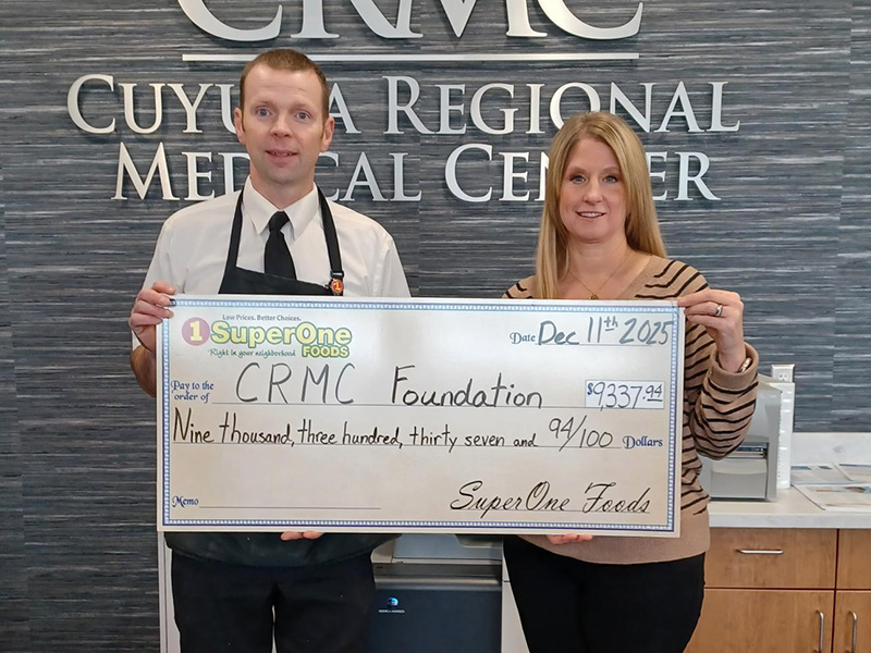 Jennifer Lowe of Cuyuna Regional Medical Center and a Super One Foods representative hold a $9,337 donation check for the CRMC Foundation Courage Cabinet.