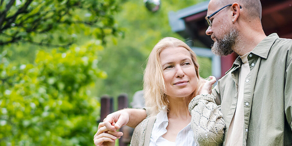 Couple outdoors talking and smiling, representing early awareness and communication about head and neck cancer symptoms and when to seek care.