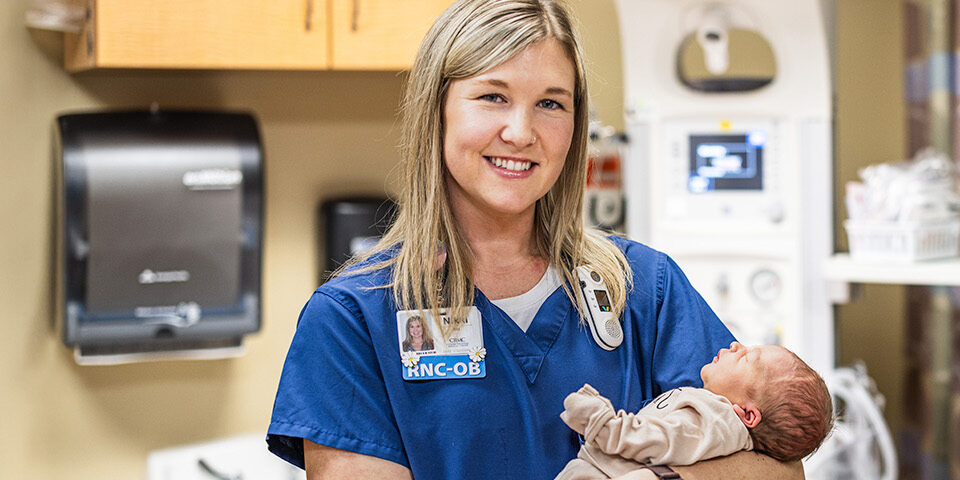 CRMC maternity nurse holding a newborn baby.